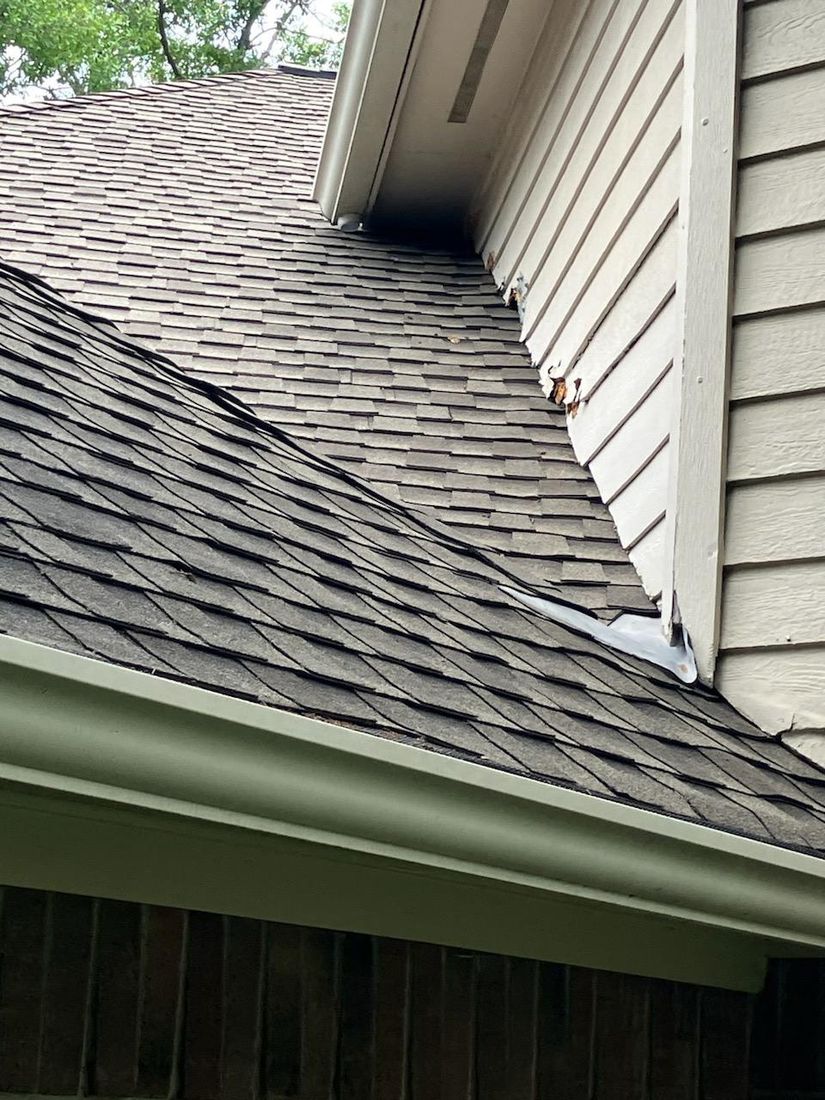 Storm-damaged siding before repair in The Woodlands, TX